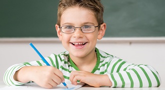 JonasBrille Junge mit Kinderbrillen in der Schule lächelnd
