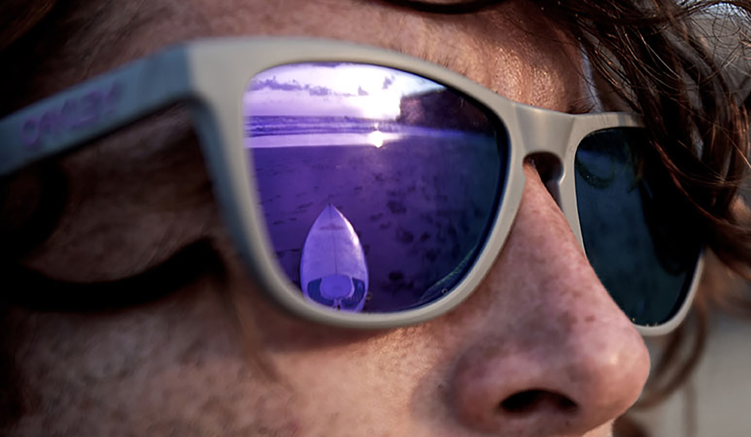 Mann am Strand mit lilafarbener Sonnenbrille als Sportbrille