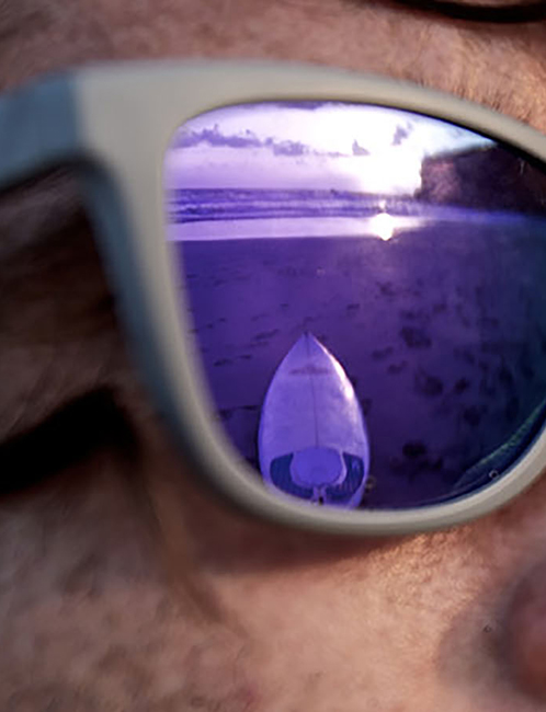 Mann mit lila Sonnenbrille am Strand