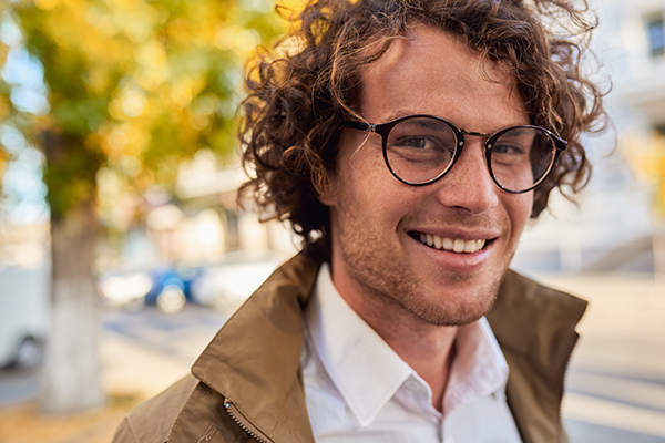 Mann mit Brille lächelt im Herbst